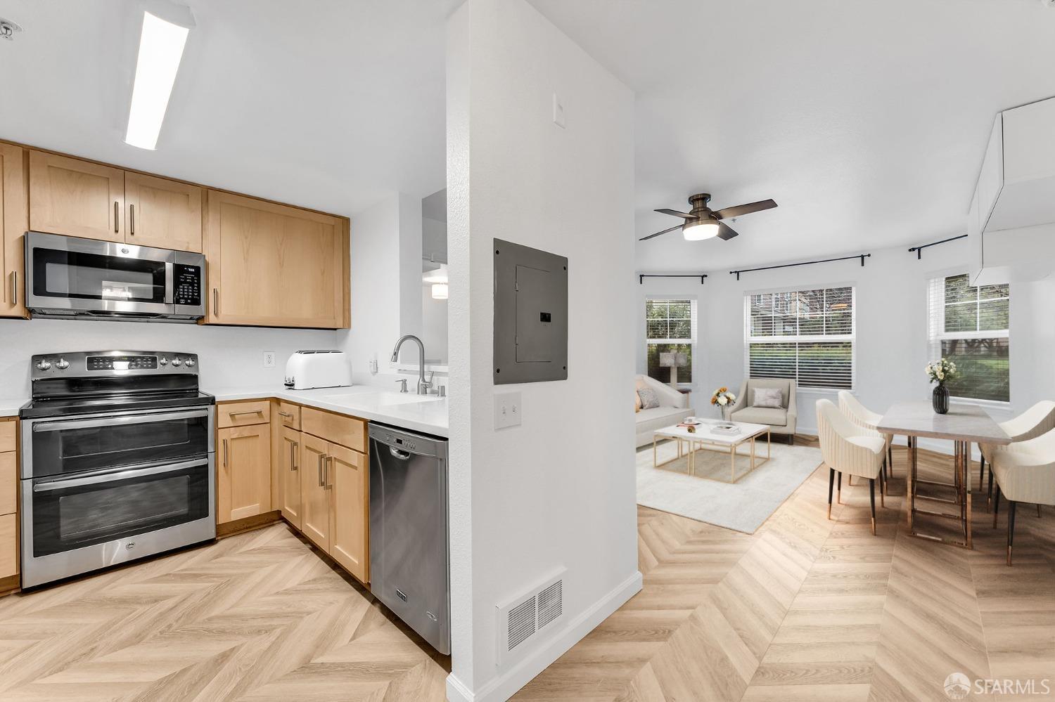 555 10th Street, Unit 102 Oakland, CA 94607 - Photo 6 of 38 a kitchen with stainless steel appliances granite countertop a stove top oven a sink dishwasher and white cabinets with wooden floor