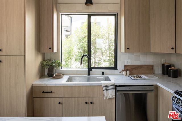 a kitchen with a sink a window and cabinets