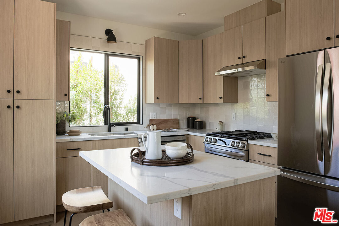 5117 Coringa Drive Los Angeles, CA 90042 - Photo 13 of 27 a kitchen with a refrigerator a stove a sink and a cabinets