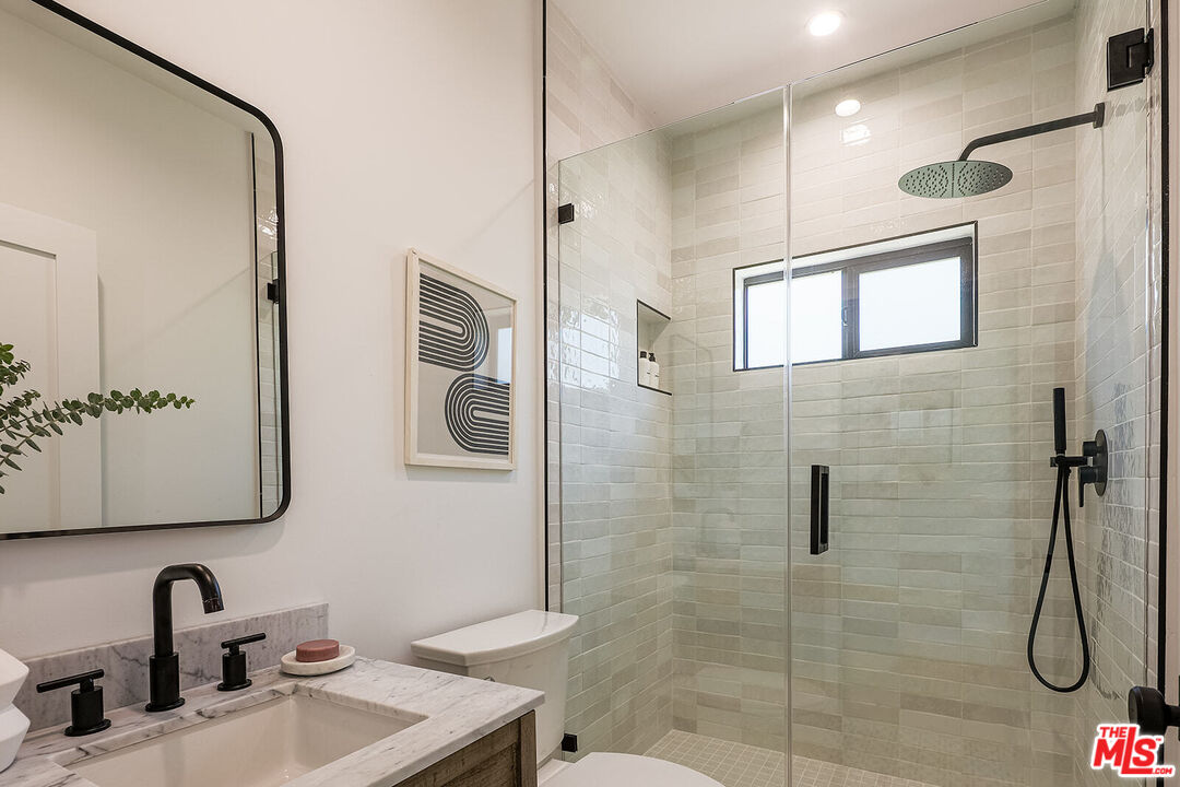 5117 Coringa Drive Los Angeles, CA 90042 - Photo 22 of 27 a bathroom with a sink shower and a mirror