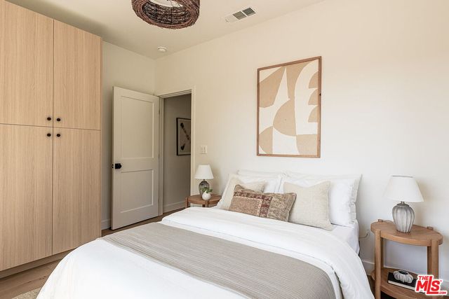 a bedroom with a bed and a painting on the wall