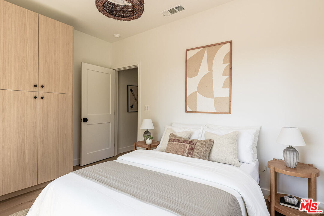 5117 Coringa Drive Los Angeles, CA 90042 - Photo 25 of 27 a bedroom with a bed and a painting on the wall