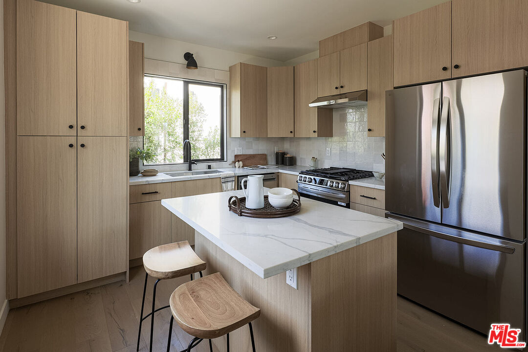 5117 Coringa Drive Los Angeles, CA 90042 - Photo 8 of 27 a kitchen with a sink a refrigerator and a stove top oven