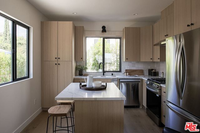 a kitchen with a refrigerator a stove a sink and a window