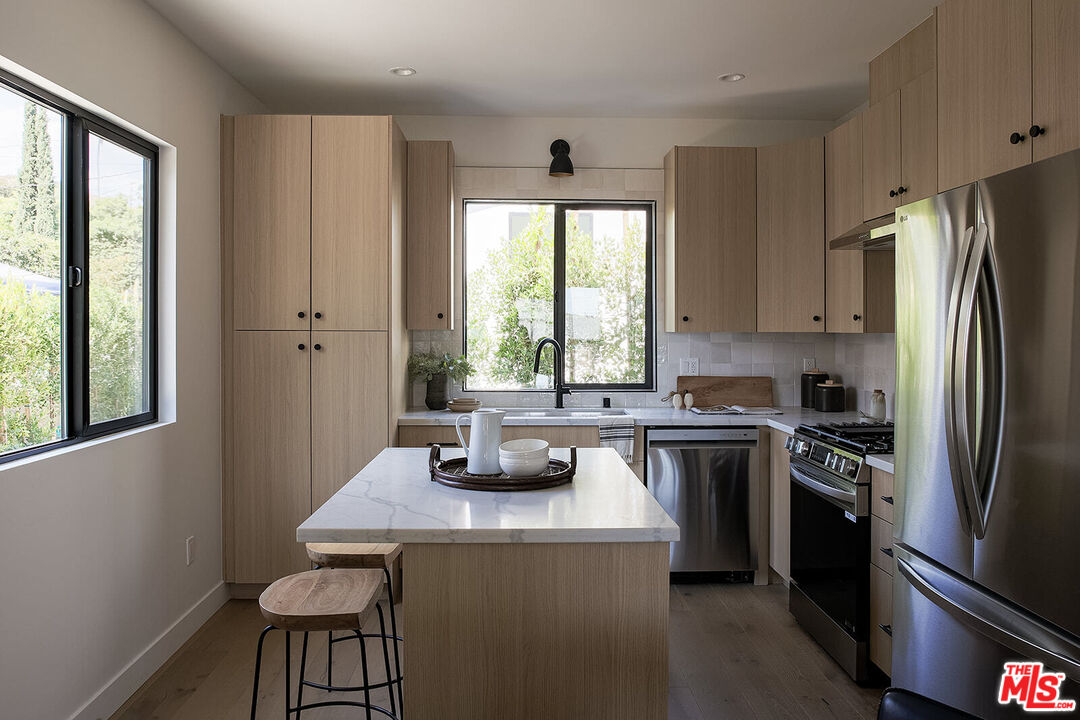 5117 Coringa Drive Los Angeles, CA 90042 - Photo 9 of 27 a kitchen with a refrigerator a stove a sink and a window