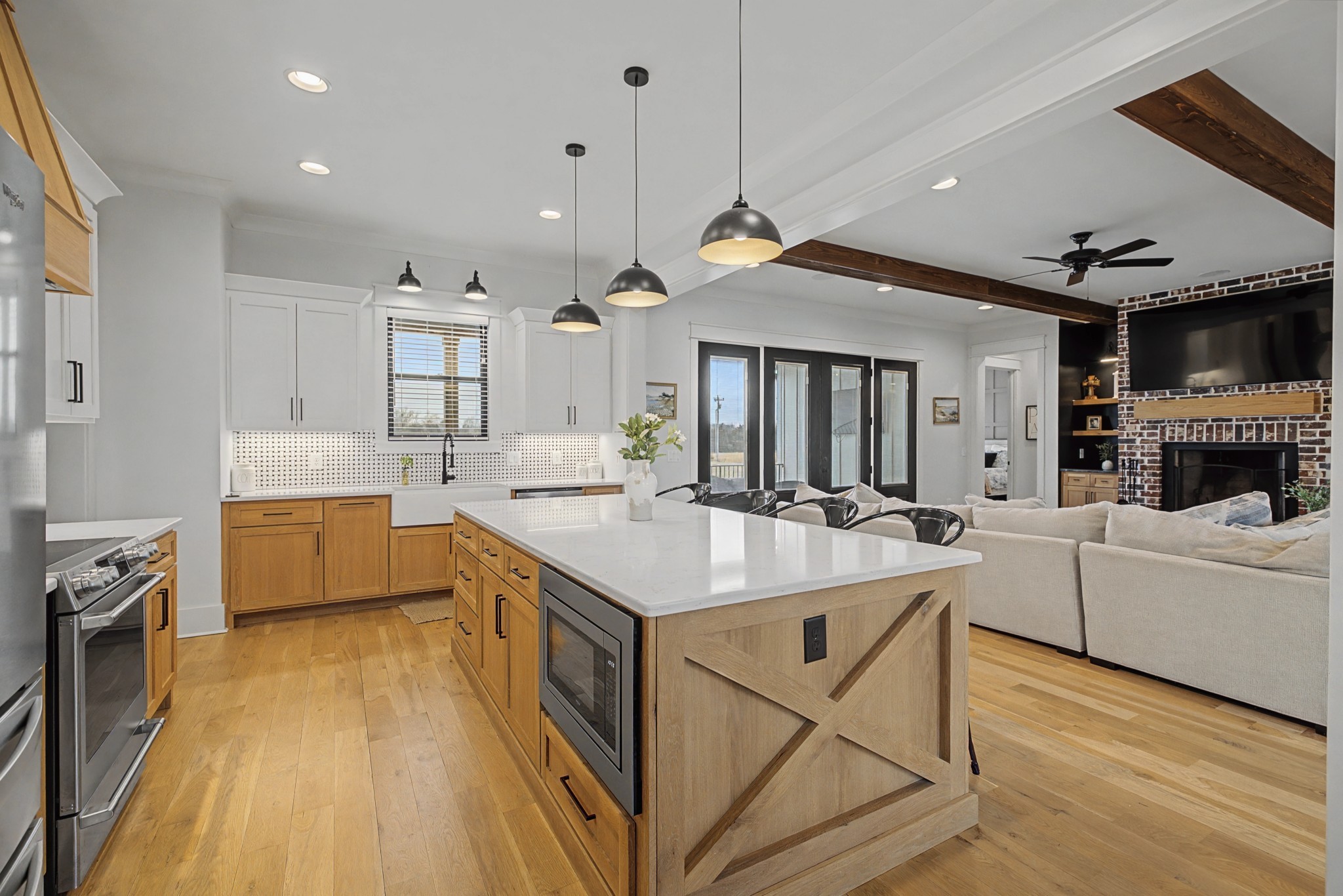 110 Squire Jones Road Bell Buckle, TN 37020 - Photo 14 of 50 a large white kitchen with a stove a sink a refrigerator and a dining table with wooden floor