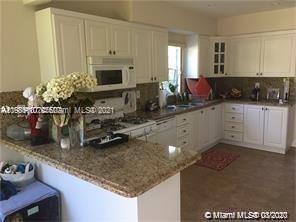 9132 Froude Avenue Surfside, FL 33154 - Photo 5 of 22 a kitchen with sink a microwave and cabinets