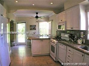 9132 Froude Avenue Surfside, FL 33154 - Photo 8 of 22 a kitchen with stainless steel appliances granite countertop a sink a stove cabinets and a dining table