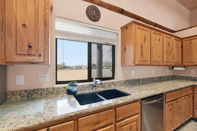 a kitchen with granite countertop a sink a stove and cabinets