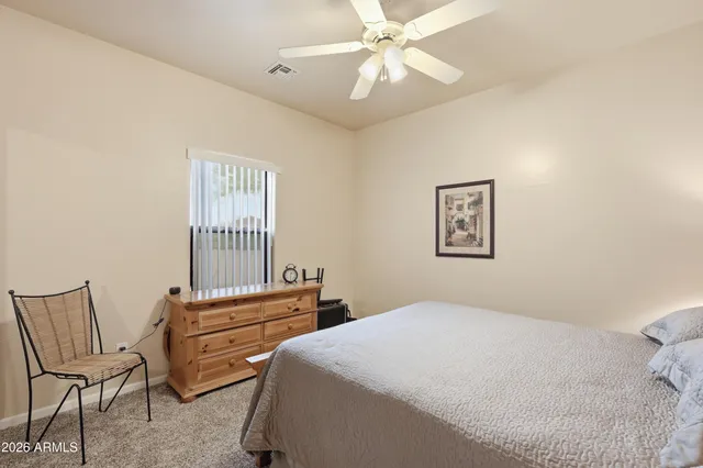 a bedroom with a bed a chair and a chandelier