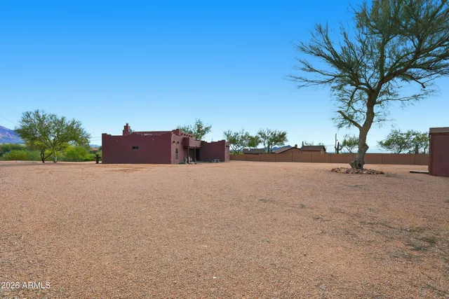 a patio with a table and chairs and potted plants