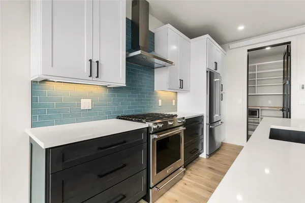 a kitchen with stainless steel appliances granite countertop a stove a sink and a refrigerator