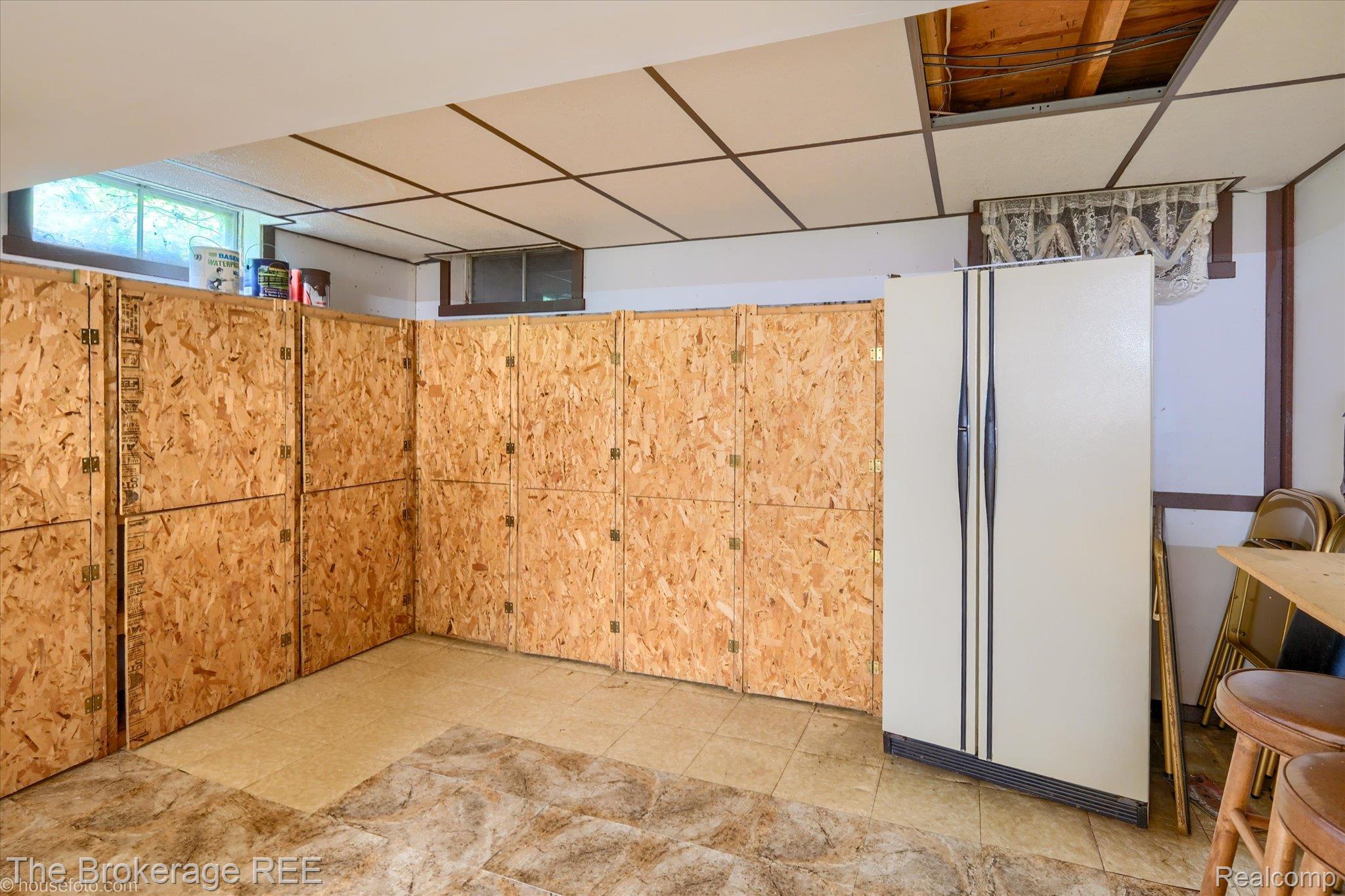 6129 East Lake Road Millington, MI 48746 - Photo 28 of 47 Basement with a drop ceiling and freestanding refrigerator