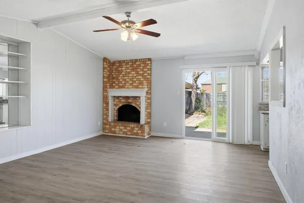 a view of an empty room with a fireplace and a window