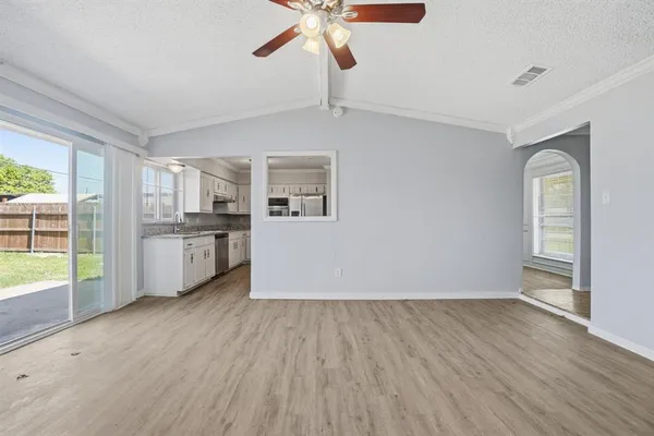 a view of a kitchen with wooden floor and a ceiling fan