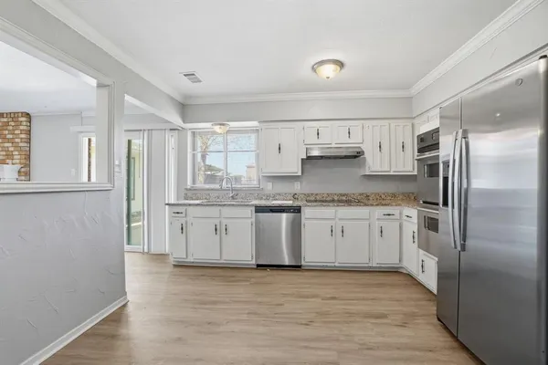 a kitchen with a refrigerator sink and cabinets