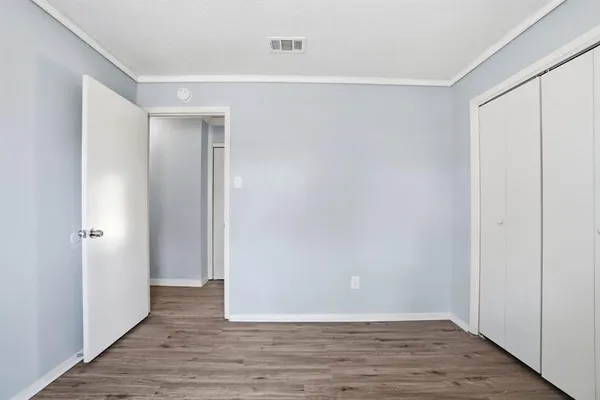 a view of an empty room with wooden floor