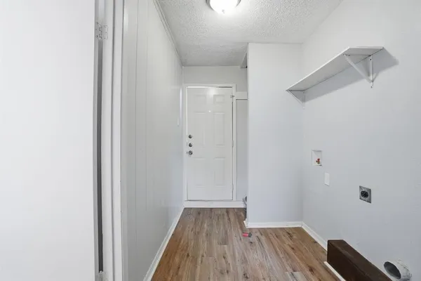 a view of a hallway with wooden floor