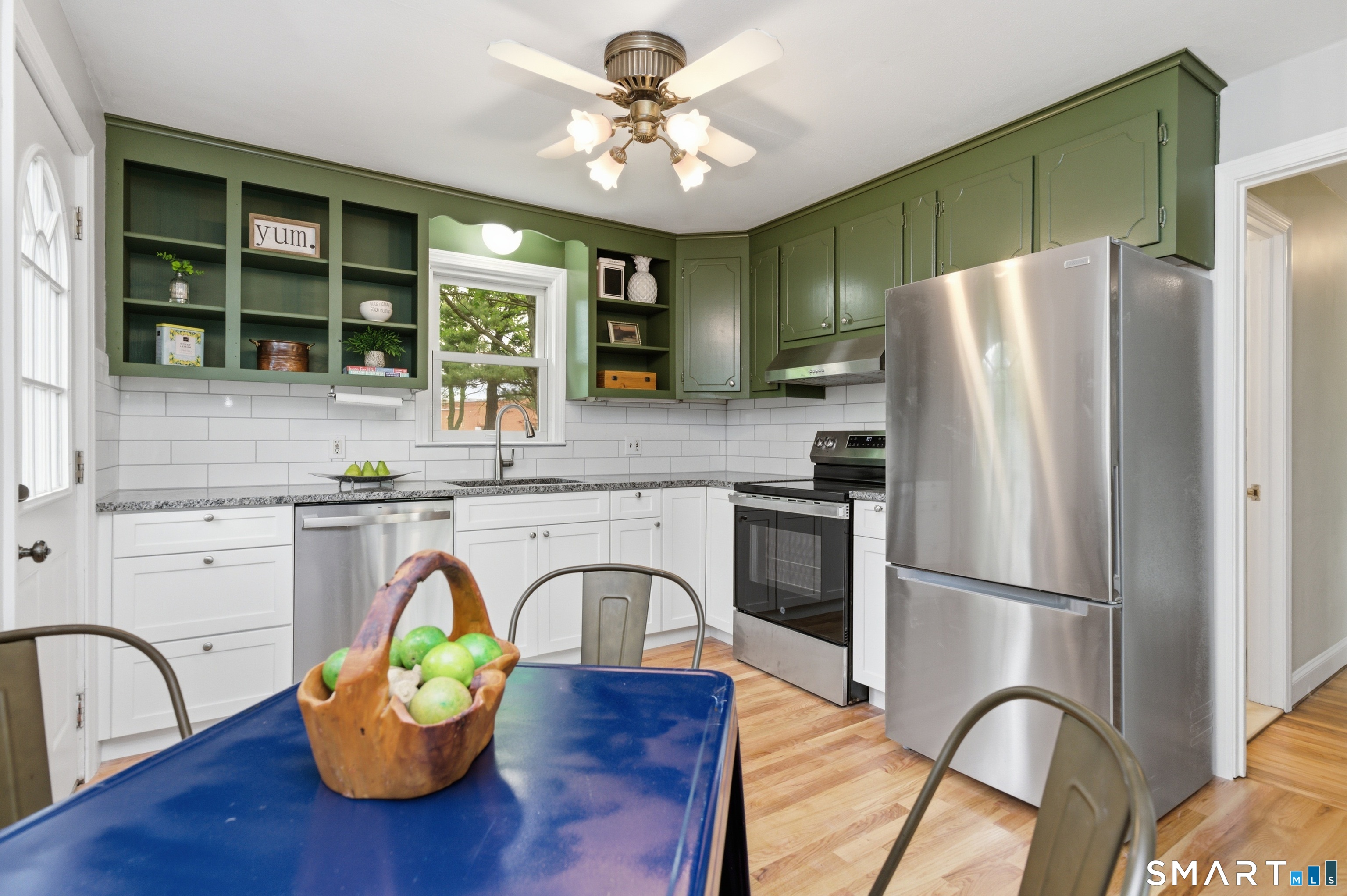 149 Mill Street Wethersfield, CT 06109 - Photo 8 of 29 a kitchen with stainless steel appliances granite countertop a refrigerator a stove a sink and a dining table with wooden floor