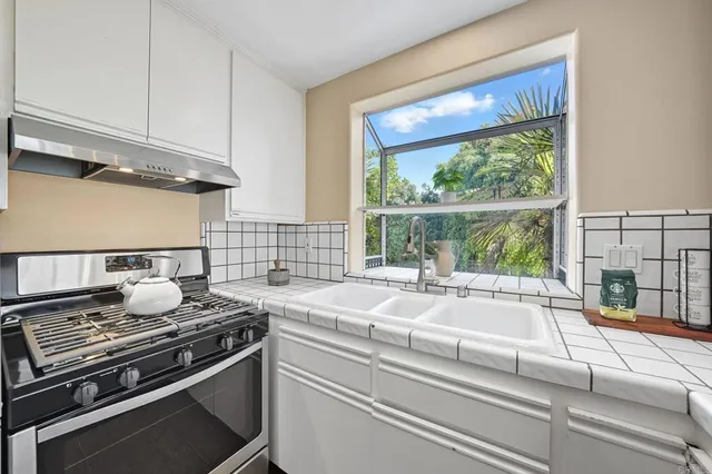 a kitchen with white cabinets and white appliances