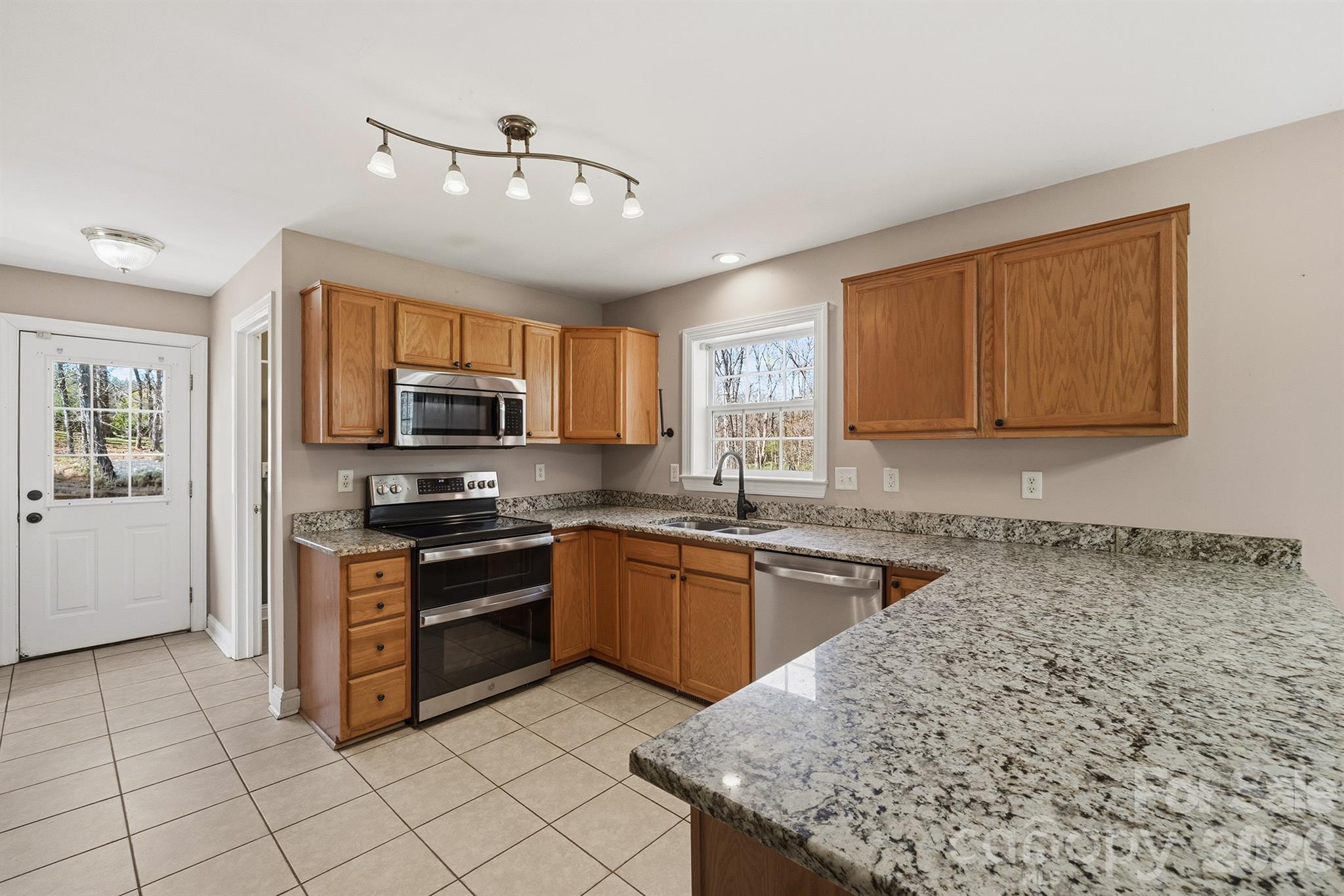 193 Red Hawk Lane Olin, NC 28660 - Photo 2 of 36 a kitchen with stainless steel appliances granite countertop a stove top oven a sink dishwasher a dining table and chairs with wooden floor