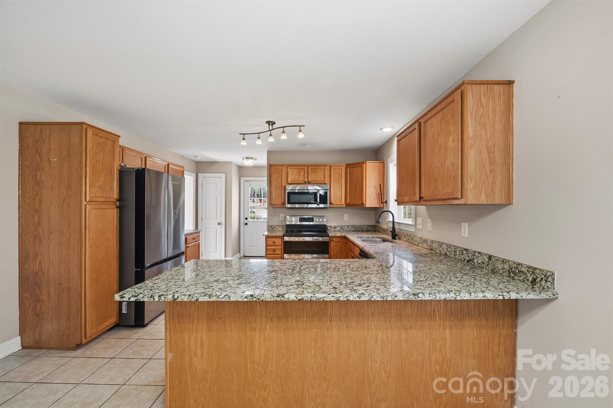 193 Red Hawk Lane Olin, NC 28660 - Photo 3 of 36 a kitchen with stainless steel appliances granite countertop a sink stove and refrigerator