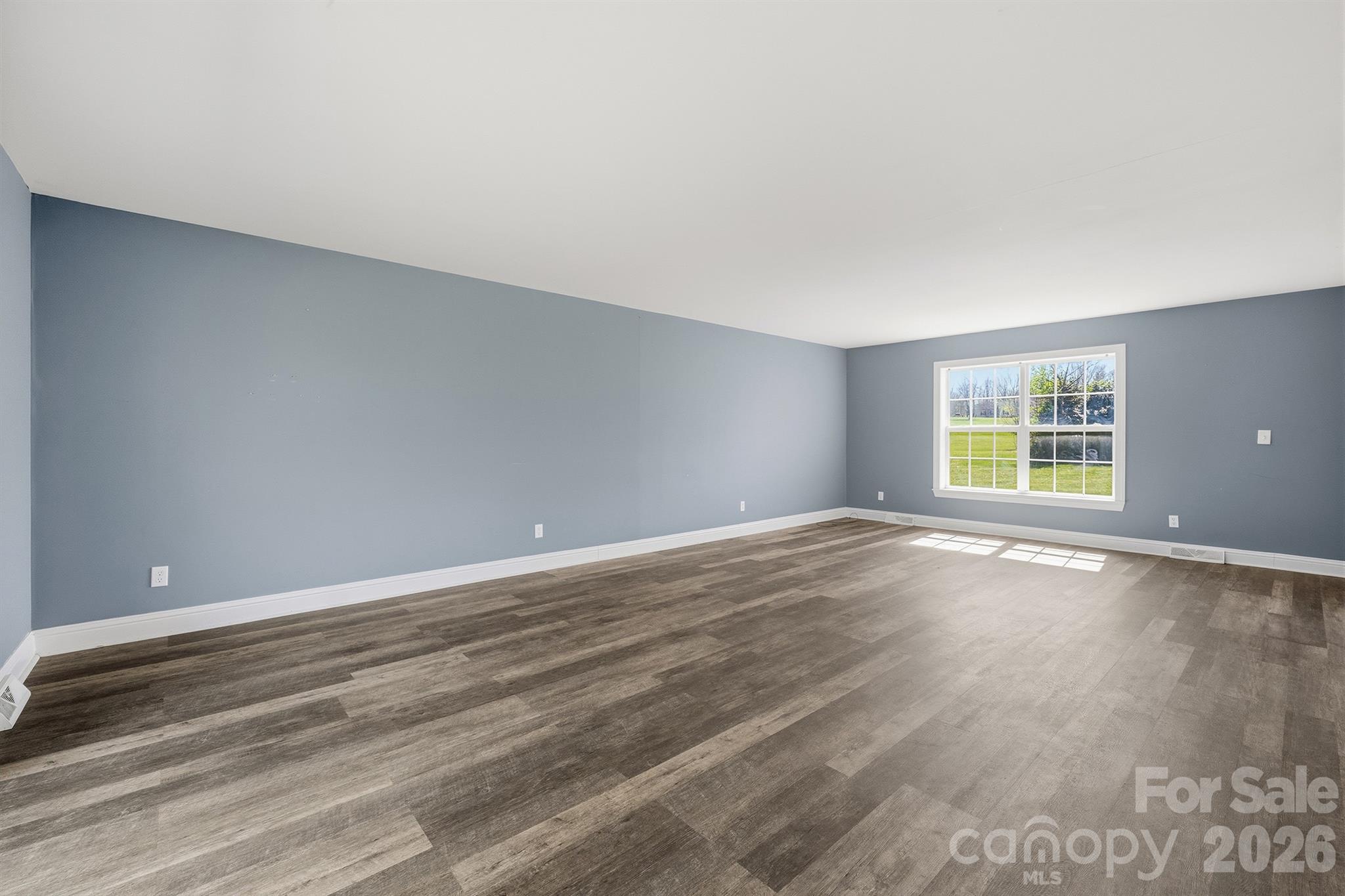 193 Red Hawk Lane Olin, NC 28660 - Photo 8 of 36 a view of an empty room with wooden floor and a window