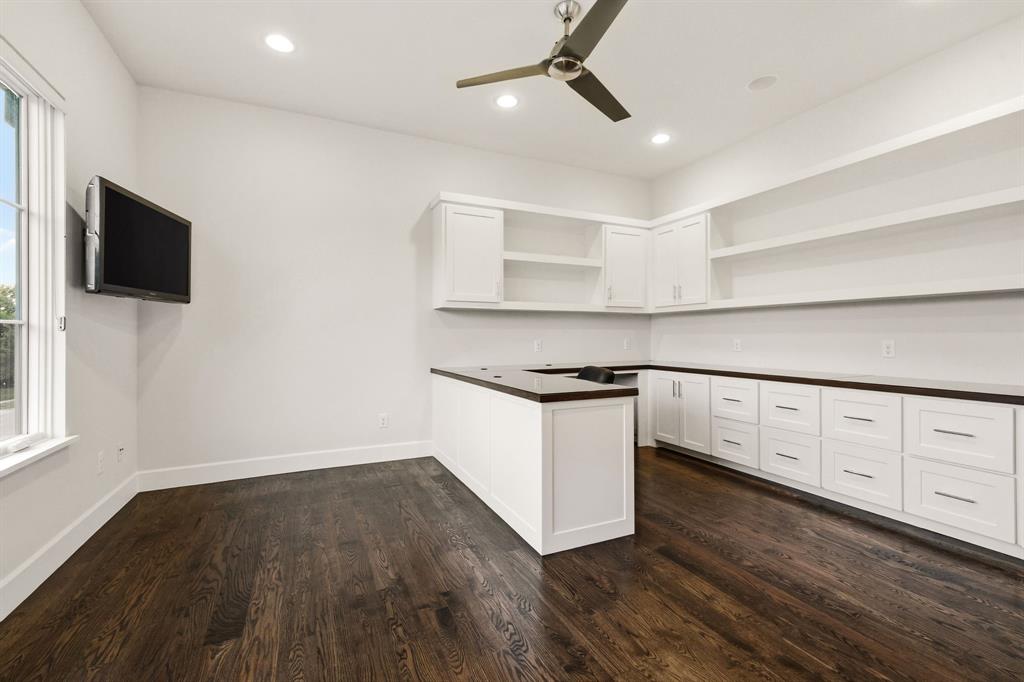 6523 Northwood Road Dallas, TX 75225 - Photo 25 of 36 a kitchen with granite countertop white cabinets and black appliances