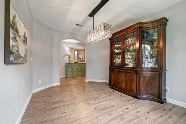 a view of a room with wooden floor chandelier and windows