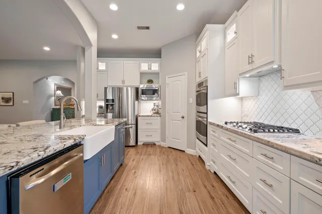 a kitchen with stainless steel appliances granite countertop wooden cabinets and sink