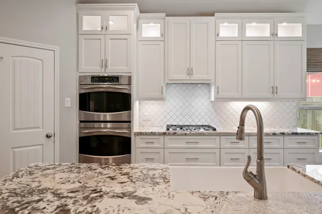 a kitchen with stainless steel appliances a stove a sink and cabinets