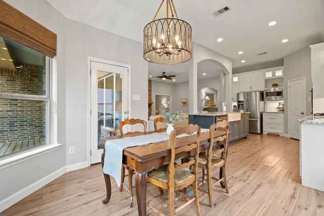 a view of a dining room with furniture a chandelier and wooden floor