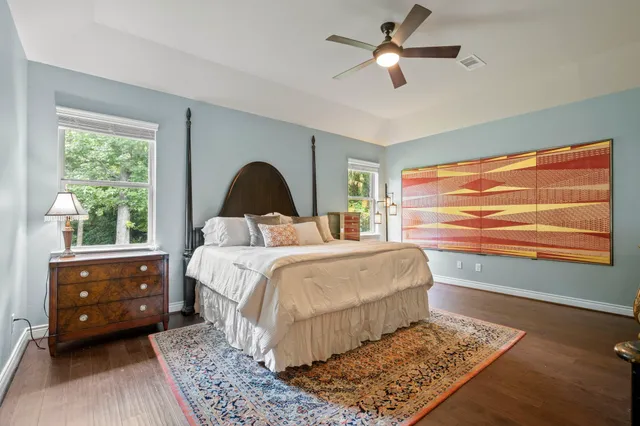 a bedroom with a bed and a dresser next to a window