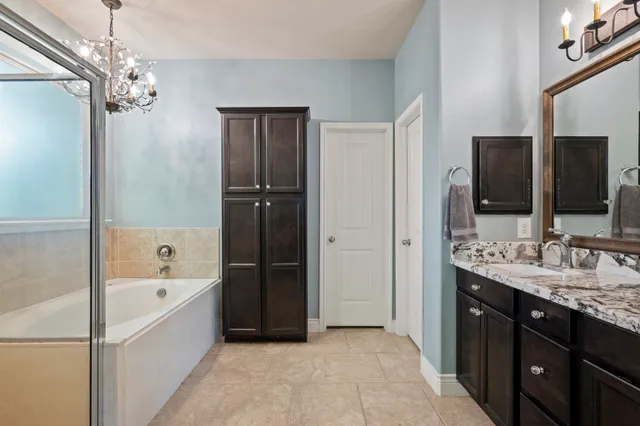 a spacious bathroom with a tub sink shower and mirror