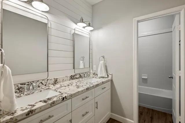 a bathroom with a granite countertop sink and a mirror