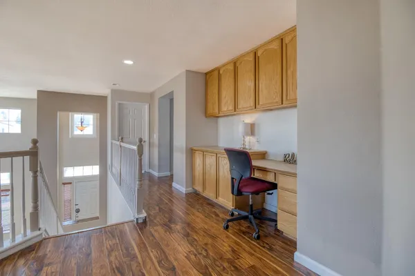 a view of a workspace with furniture and wooden floor