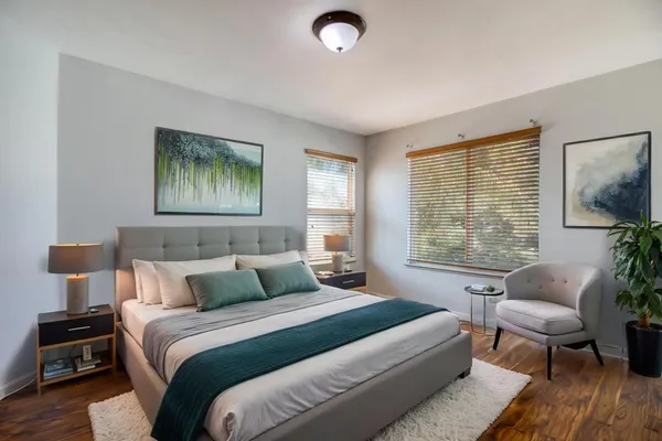 a bedroom with a bed and wooden floor