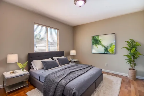 a bedroom with bed and a potted plant