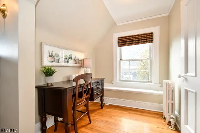a view of a workspace with furniture and a window