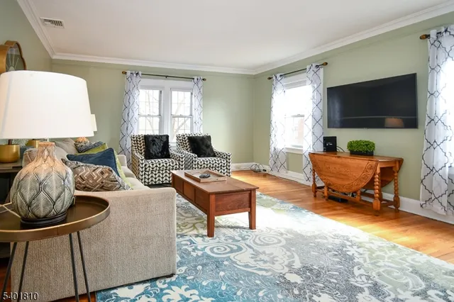 a living room with furniture a flat screen tv and a window