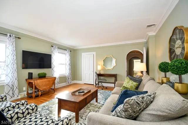 a living room with furniture a flat screen tv and a large window