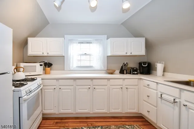 a kitchen with white cabinets and white appliances