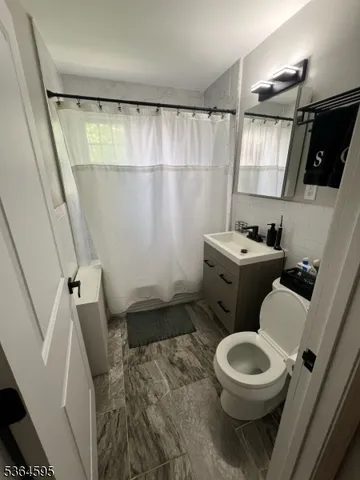 a white toilet sitting next to a bathroom sink and a shower
