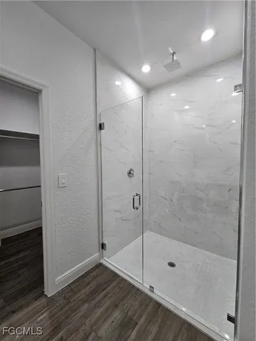 a bathroom with a shower a toilet and a glass window