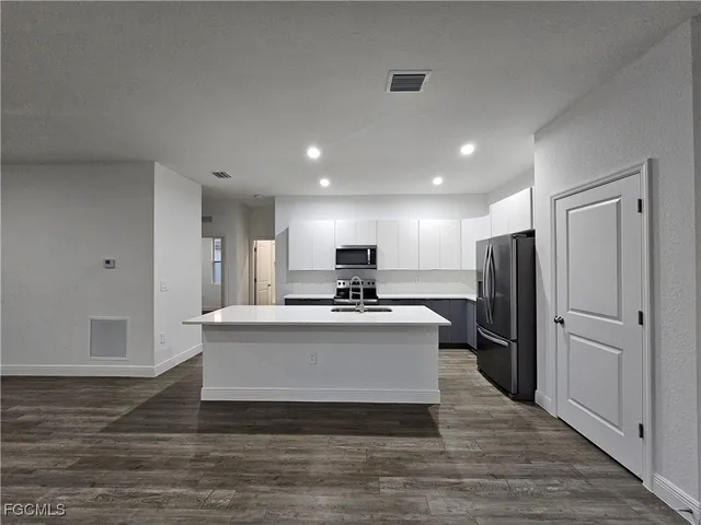 a view of kitchen with stainless steel appliances kitchen island sink stove and refrigerator
