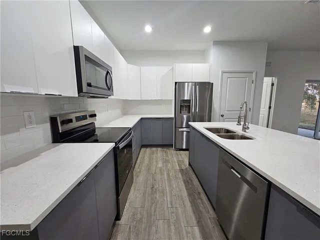 a kitchen with stainless steel appliances a sink stove and refrigerator