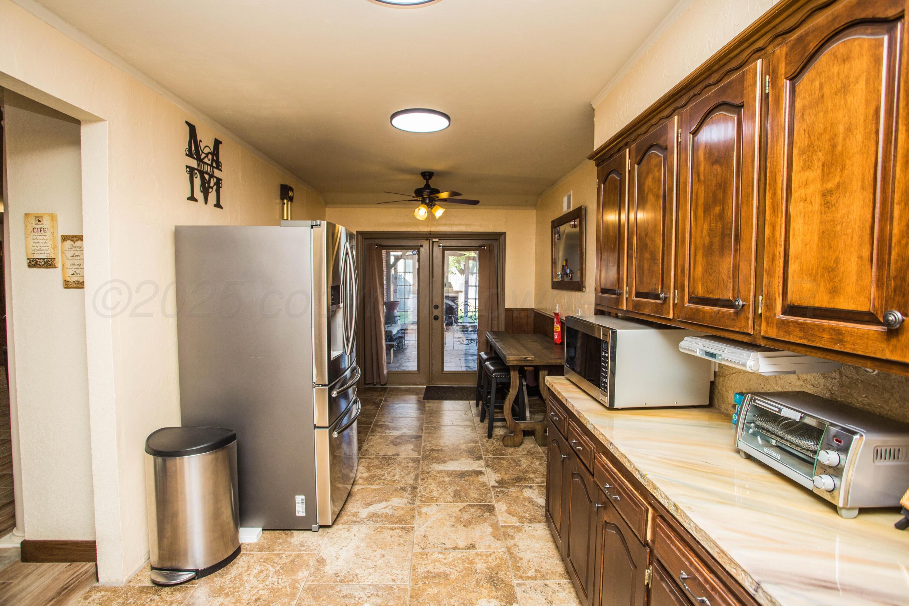 402 Northwest 6th Street Tulia, TX 79088 - Photo 19 of 59 a kitchen with stainless steel appliances granite countertop a refrigerator a stove and a sink with cabinets