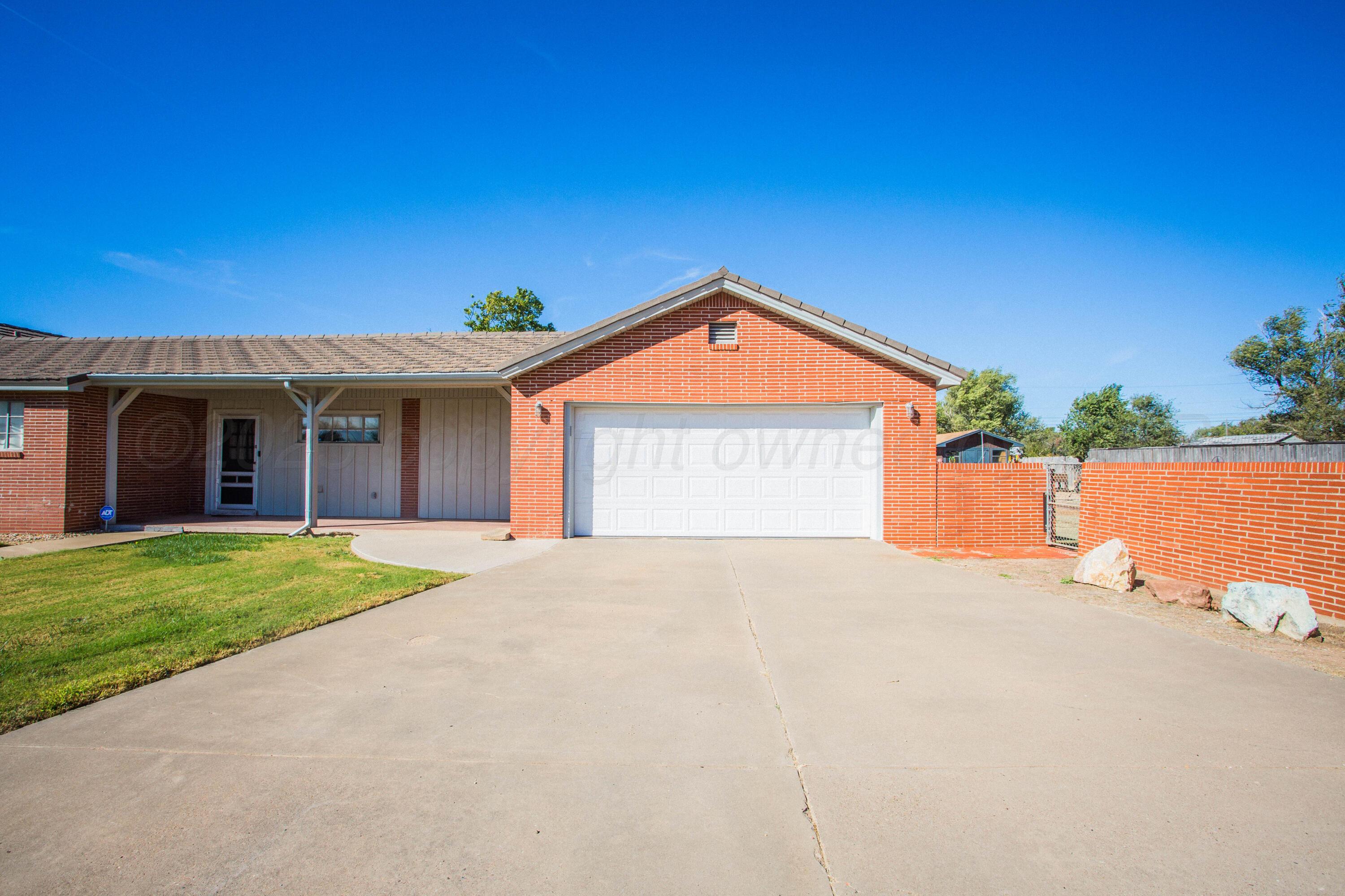 402 Northwest 6th Street Tulia, TX 79088 - Photo 2 of 59 a front view of a house with a yard and garage