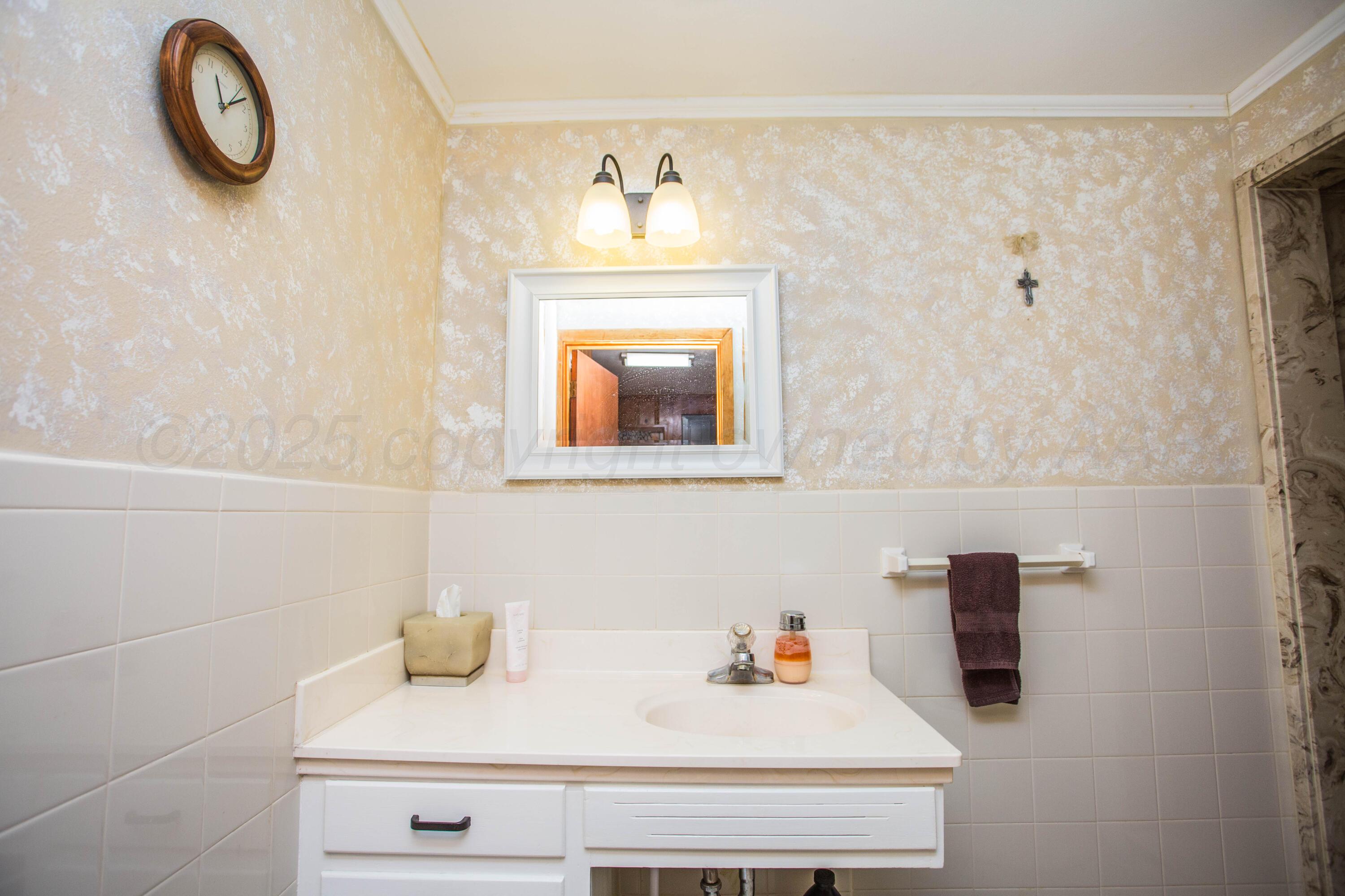 402 Northwest 6th Street Tulia, TX 79088 - Photo 41 of 59 a bathroom with a sink and a mirror