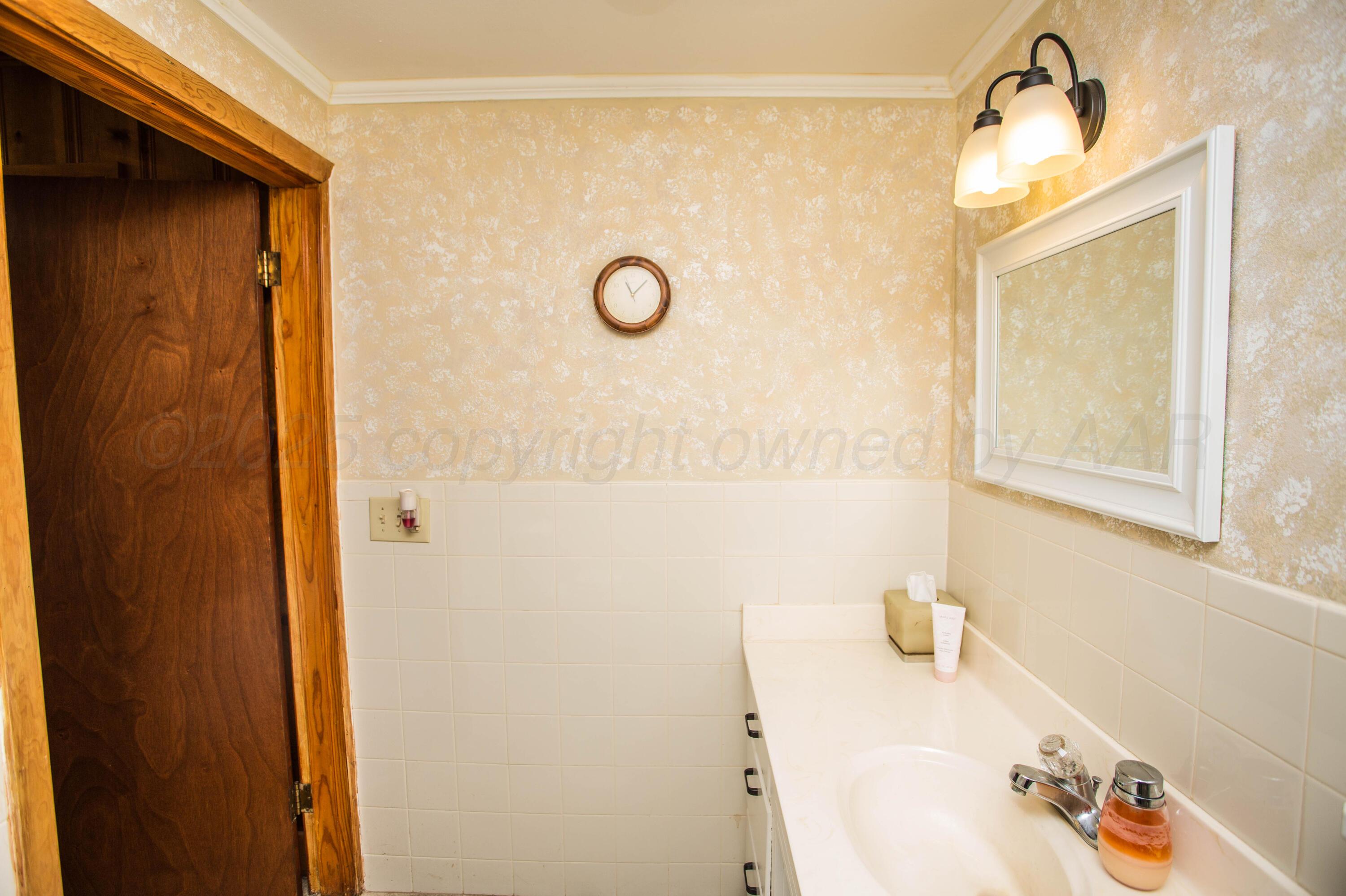 402 Northwest 6th Street Tulia, TX 79088 - Photo 44 of 59 a bathroom with a tub a sink and a mirror